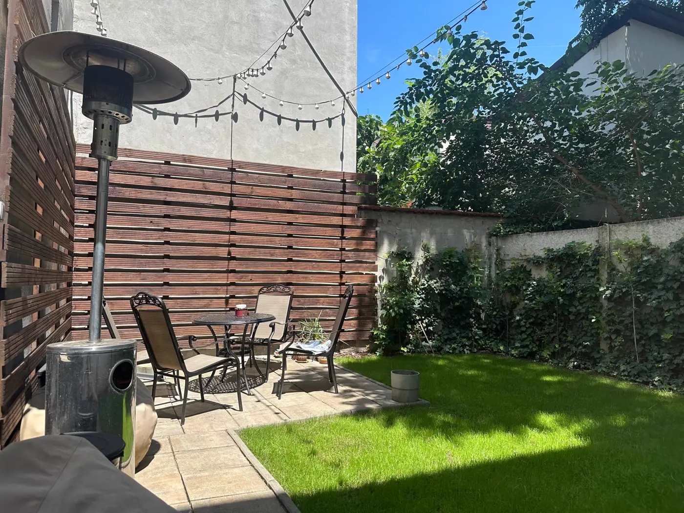 Andrei's garden – a table, grass and string lights: his open-air office.